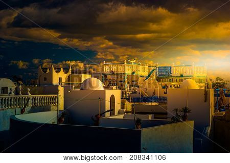 Hammamet, Tunisia. Image of architecture of old medina with dramatic sky at sunset time.