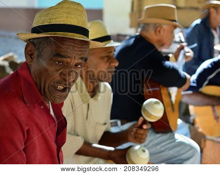 TRINIDAD CUBA - 08 NOVEMBER 2016: Portrait of Latino American men of musicians play on maracases guitar and small drums and sing songs