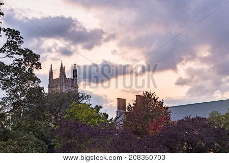 beautiful dramatic cloudy sky at sunsut hidden castle tower behind colorful trees in autumn colors