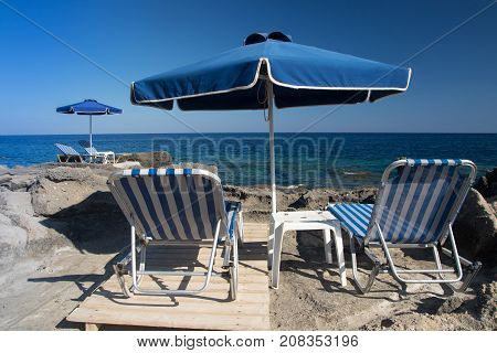 Blue Sunshade and sun beds on Kalithea beach Rhodes island Greece