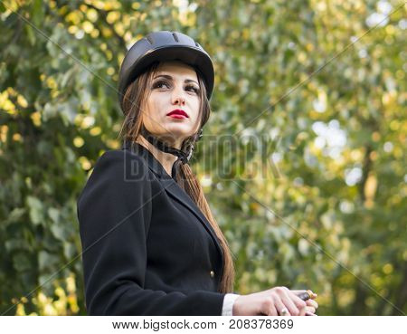 Young brunette beauty jokey girl riding horse in the green park