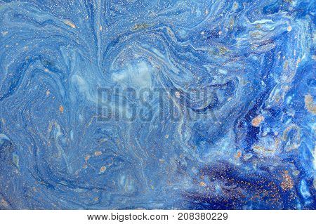 Marbled blue abstract background with golden sequins. Liquid marble ink pattern