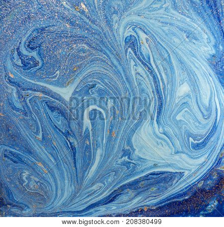 Marbled blue abstract background with golden sequins. Liquid marble ink pattern