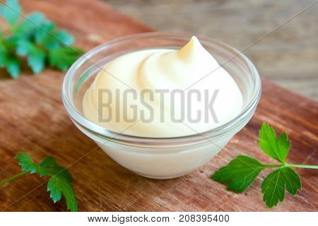Mayonnaise sauce over rustic wooden background. Mayonnaise.