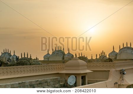 Rooftops of a hindu temple in Nahargarh Jaipur. Shows a mix of the old architecture style with domes, arches, spires and canopies and the satellite dishes installed for connectivity