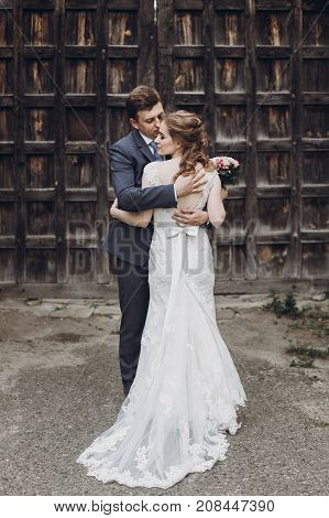 Beautiful Gorgeous Bride And Groom Kissing. Happy Wedding Couple Hugging And Embracing At Old Castle