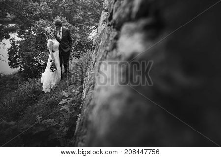 Beautiful Gorgeous Bride And Groom Posing. Happy Wedding Couple Hugging And Embracing At Old Castle.