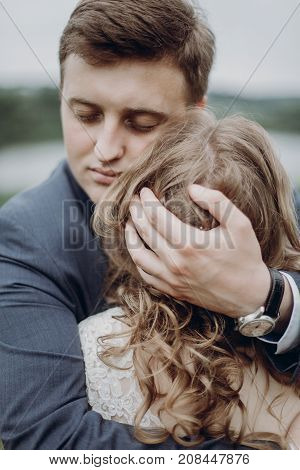 Groom Embracing And Hugging Beautiful Gorgeous Bride. Happy Sensual Wedding Couple In Love, Atmosphe