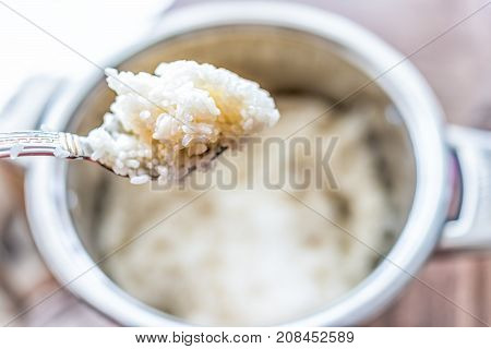 Macro Closeup Of Spoonful Of Fresh Cooked Rice By Cooking Pot On Table Showing Detail And Texture