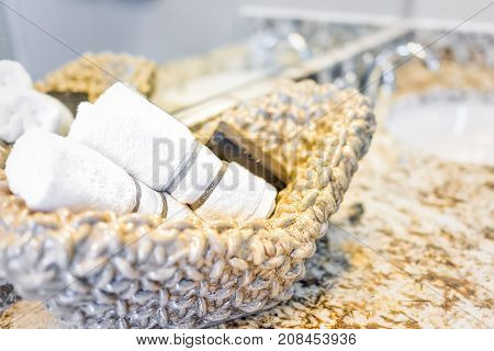 Closeup Of Soap And Hand Towels In Woven Basket In Bathroom Granite Countertop With Sink And Mirror