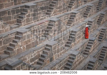 Baswa India : 19th February 2015 - A shot of an Indian female going down lots of stairs at Chand Baori Step Well in India just to get some water.