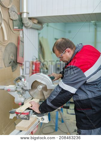 Gray machine circular saw with protection so as not to harm yourself, against the background of the fire extinguisher