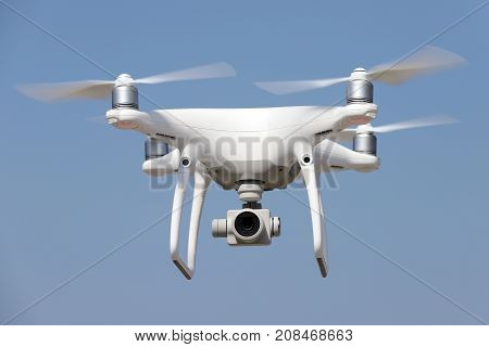 KAGAWA, JAPAN - OCTOBER 10, 2017: White remote controlled Drone Dji Phantom4 Pro equipped with high resolution video camera flying in air and blue sky in the background