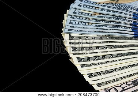 Stack of one hundred dollar bills. Stack of cash money in hundred dollar banknotes. Heap of hundred dollar bills isolated on black background