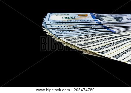Stack of one hundred dollar bills. Stack of cash money in hundred dollar banknotes. Heap of hundred dollar bills isolated on black background