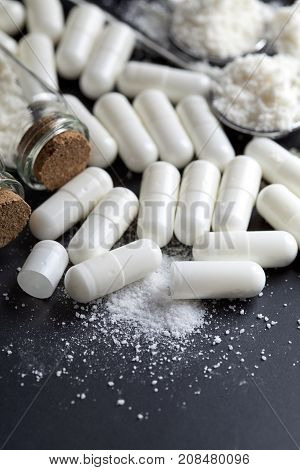 Medicine Capsules And Glass Containers On Black Table