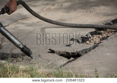 Road Repairing Works With Jackhammer. Male Worker Using Jackhammer Pneumatic Drill Machinery On Road