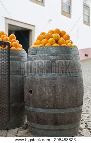 Orange Fruits on top of Big Oak wooden Barrels