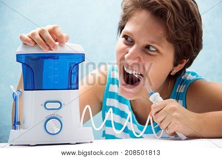 Beautiful And Crazy Girl Opened Her Mouth Wide And Brushed Her Teeth With An Irrigator With A Nozzle