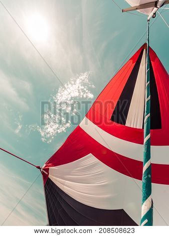 Spinnaker With Uphaul, Blue Sky In Background.
