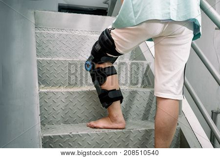 Patient with knee brace in moving upstairs