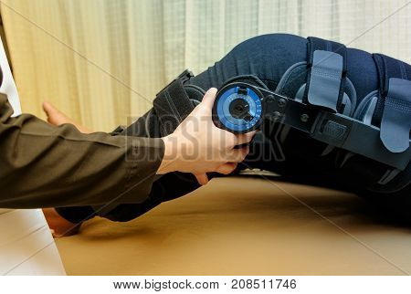 Physiotherapist adjust knee braces on patient 's leg in hospital