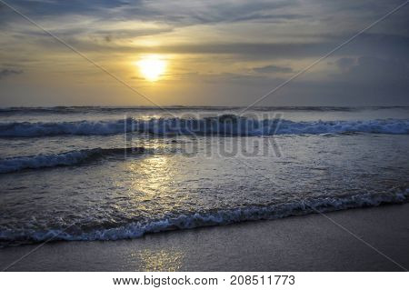Amazing beautiful sea landscape sunset view of Seminyak Double Six beach in Bali island of Indonesia with a wild wavy sea and orange sky in travel tourism and Asia exotic holidays and vacation concept