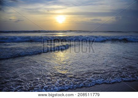 Amazing beautiful sea landscape sunset view of Seminyak Double Six beach in Bali island of Indonesia with a wild wavy sea and orange sky in travel tourism and Asia exotic holidays and vacation concept