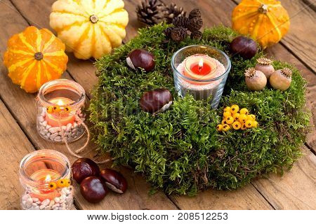 Autumnal decoration - moss wreath pumpkins and candles