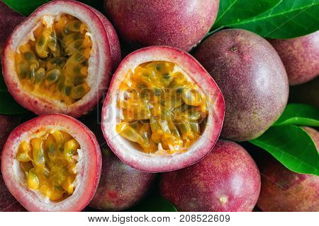 Fresh passion fruit on wood table in top view flat lay for background or wallpaper. Ripe passion fruit so delicious sweet and sour. Close up on a half of passion fruit in macro concept. Passion fruit is tropical fruit.