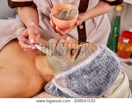 Collagen face mask. Facial skin treatment. Face of woman of elderly woman 50-60 years old receiving cosmetic procedure in beauty salon close up. Healing clay for the face.