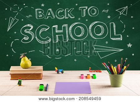 Back to school concepty with writing on blackboard and desk, apple, books, items