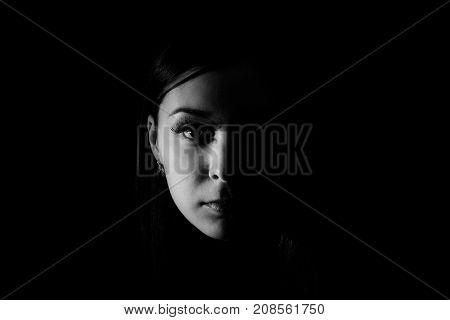 Black and white photo of the Beautiful woman face in the darkness