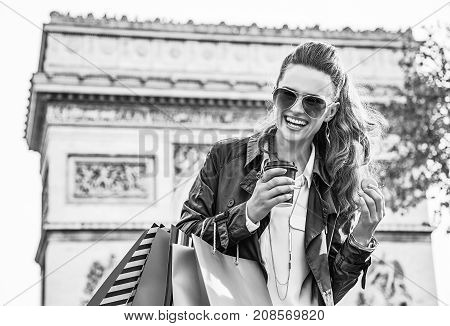 Stylish autumn in Paris. happy elegant fashion-monger in sunglasses with shopping bags in Paris France having coffee and macaroon