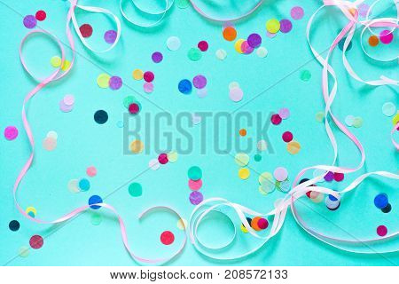 Festive party or carnival confetti on a mint color background with copy space