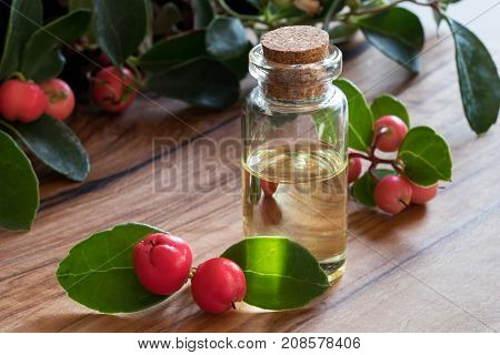 A Bottle Of Wintergreen Essential Oil On A Wooden Table