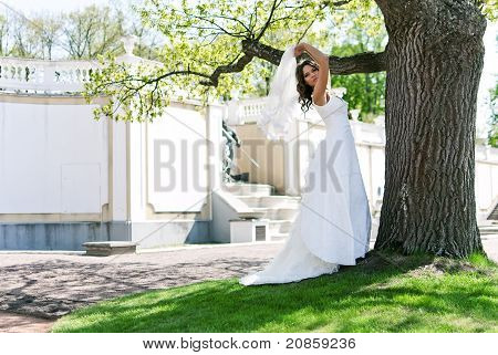 Debout près d'un arbre dans un parc près du Palais de la mariée