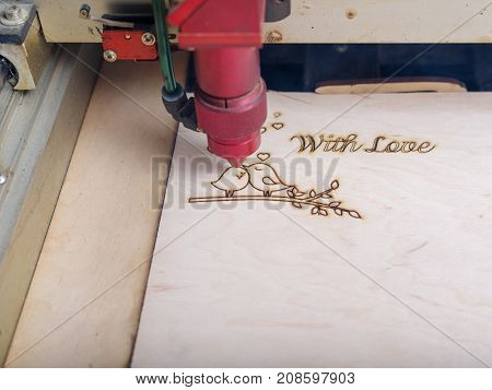Automated machine for the burning of patterns on the tree began its work on patterns and inscriptions close-up