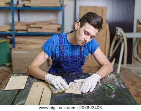 A carved plate on which the patterns and inscriptions are burned out that the master in blue overalls handle with a special tool