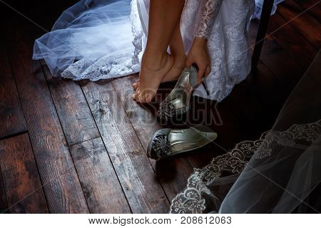 the bride wears white shoes on foot in the wedding day. close-up shoot