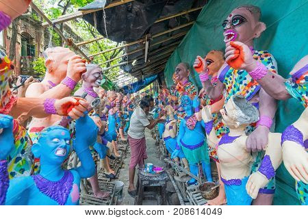 KUMARTULI KOLKATA INDIA - OCTOBER 10 2014 - Artist preparing clay idols of female demons to be used during Kali Puja worshipping of Goddess Kali Hindu festival of Deepavali or Diwali.