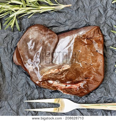 Healthy Fod Raw Liver With Rosemary On A Black Background