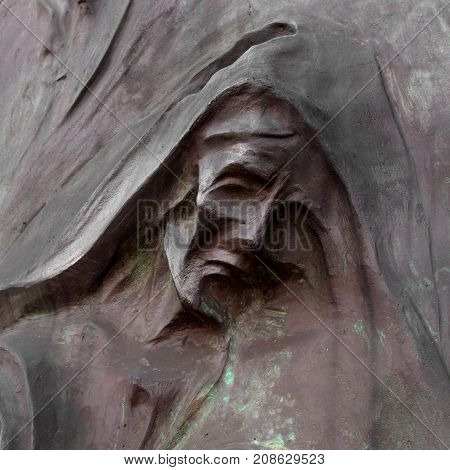 Detail of a mourning sculpture on a cemetery. (Religion faith suffering concept).