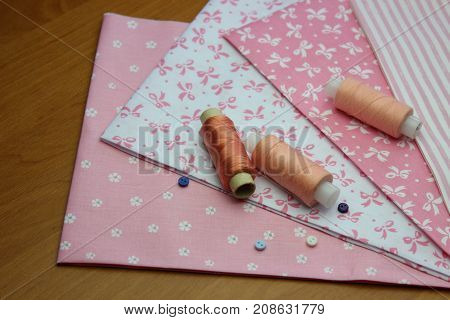 Multicolored cuts of fabric with coils of thread on the background of boards