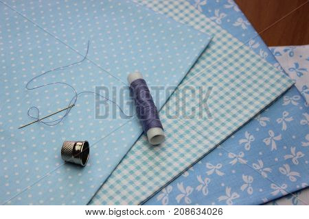 Multicolored cuts of fabric with coils of thread on the background of boards