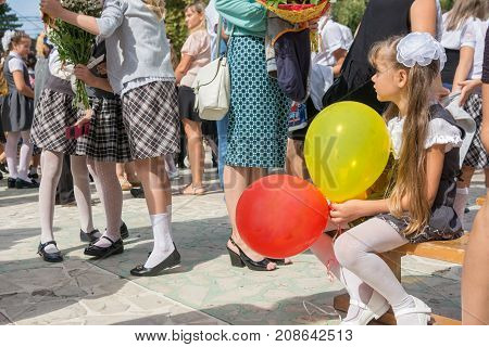 Anana Russia - September 1 2017: The first-grader looks sadly at a meeting of girlfriends on the feast of the first of September