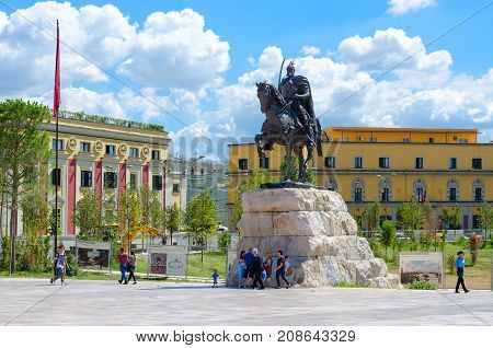 TIRANA ALBANIA - SEPTEMBER 6 2017: Unknown people are walking on Skanderbeg Square near monument to Scanderbeg national hero of Albania