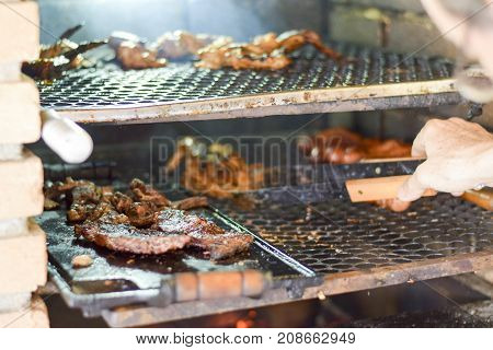 Brazilian Man Tending To Churrasco
