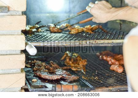 Brazilian Man Tending To Churrasco