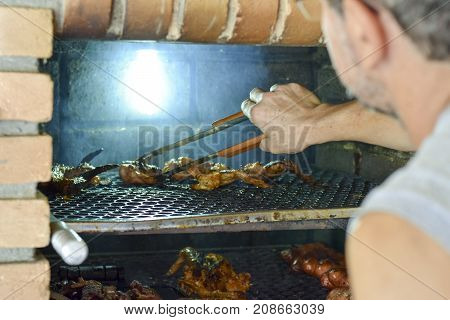 Brazilian Man Tending To Churrasco